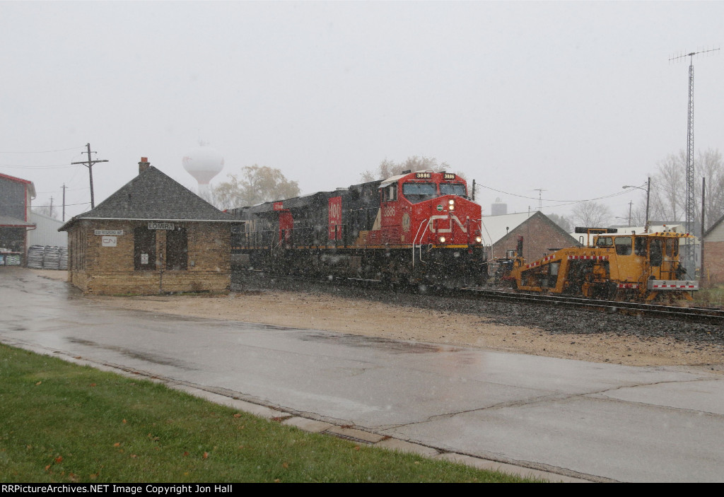 As a brief snow squall passes, X342 rolls past the old depot